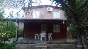 a house with two chairs and a table on a porch at Posada del Arroyo in Las Rabonas