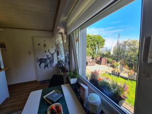 ein Zimmer mit einem Fenster mit Blick auf einen Garten in der Unterkunft Ferienwohnungen Dorfliebe Dörnberg GARTENBLICK in Bestwig