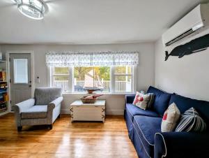 un soggiorno con un divano blu e una sedia di Beach Vibes Acadia Cottage Fire pit Family Acadia sleeps 8 a Sullivan