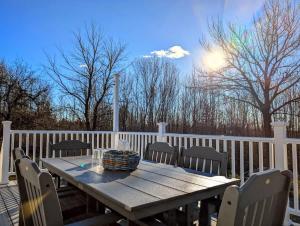 un tavolo e sedie in legno su una terrazza di Beach Vibes Acadia Cottage Fire pit Family Acadia sleeps 8 a Sullivan Altre 39 foto