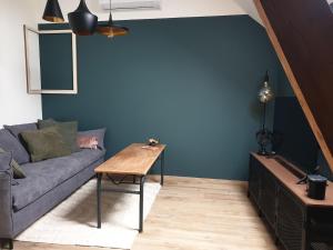 a living room with a couch and a table at Appartement La Buissonnière in Chevrières