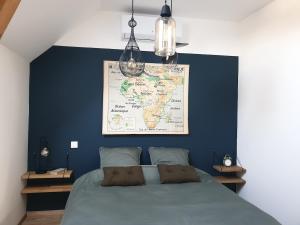 a bedroom with a bed with a map on the wall at Appartement La Buissonnière in Chevrières