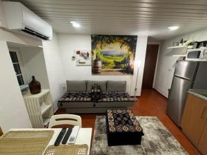 a living room with a couch and a kitchen at Sobreira Stone Cottage in Peso da Régua
