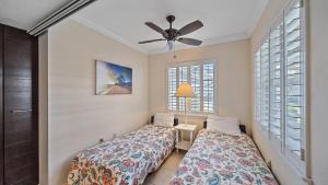 een slaapkamer met twee bedden en een plafondventilator bij Siesta Bayside Bliss in Siesta Key