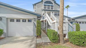 een huis met witte garagedeuren en een palmboom bij Siesta Bayside Bliss in Siesta Key