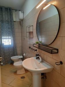 Un baño con lavabo, espejo e inodoro. en Villa GEMMA, en Castel Volturno