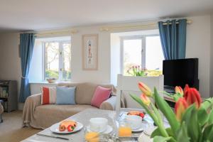 ein Wohnzimmer mit Sofa und Tisch mit Essen drauf in der Unterkunft Tinkers Cottage in Kingsbridge