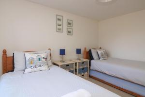 ein Schlafzimmer mit zwei Betten und zwei Nachttischen in der Unterkunft Tinkers Cottage in Kingsbridge