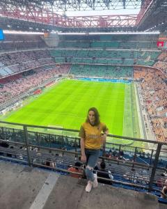 a woman standing in the stands at a soccer stadium at Gloria Hostel Milano in Milan