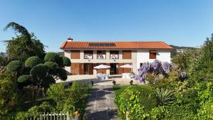 ein Haus mit einem Garten davor in der Unterkunft Vibrant Host Solutions-Aldeia da Graça in Guimarães