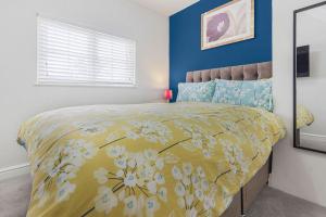 ein Schlafzimmer mit einem Bett mit gelber Decke in der Unterkunft OnSiteStays - Cute Cottage In Barcombe in Lewes