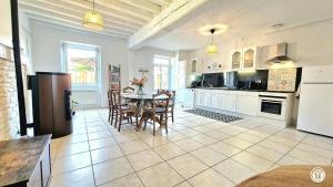 a kitchen and dining room with a table and chairs at La Sauveroise in Saint-Sauveur-en-Puisaye