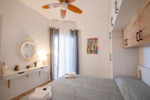 a bedroom with a bed with a ceiling fan and a mirror at Arline's Luxury Retreat House in Sarandë +41 photos