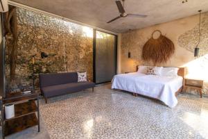 メリダにあるCasa Pepen by Kanaa - Colonial Luxury with a Private Outdoor Pool and Garden in Central Meridaのベッドとソファのある寝室 +34枚の写真