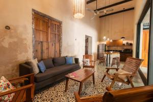 メリダにあるCasa Pepen by Kanaa - Colonial Luxury with a Private Outdoor Pool and Garden in Central Meridaのソファとテーブルのあるリビングルーム