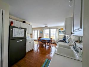 una cucina con frigorifero nero e tavolo di Sunrise Oceanside Cottage Family Ocean Acadia a Surry