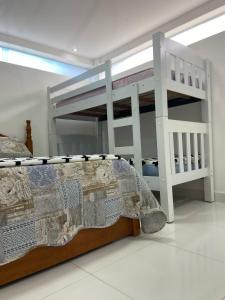 卡波布里奥Studio no Condomínio dos Pássaros em Cabo Frio e Belas Praias的带双层床和梯子的卧室