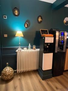 a room with a heater and a table with a lamp at Hôtel Beausoleil in Montélimar +63 photos