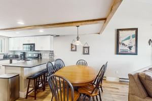 Una cocina y un comedor con mesa y sillas de madera. en Fraser's Mountain Fantasy, en Fraser