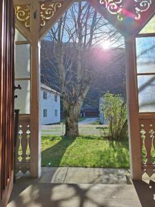an open door to a yard with a tree at Villa ved sjøen og fjellene in Myklebostad
