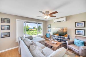 a living room with couches and a ceiling fan at Hale Kahana'lu in Koloa