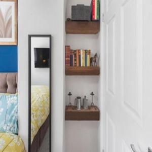 Zimmer mit einem Bett und Regalen mit Büchern in der Unterkunft OnSiteStays - Cute Cottage In Barcombe in Lewes