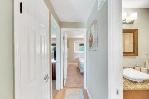 a hallway with a bathroom with a tub and a sink at Hale Kahana'lu in Koloa +18 photos
