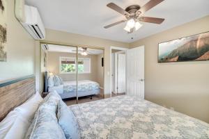a bedroom with a bed and a ceiling fan at Hale Kahana'lu in Koloa