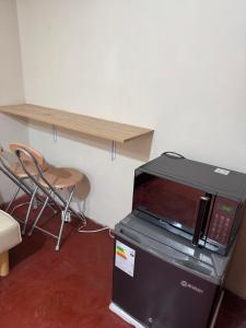 a microwave sitting on top of a refrigerator next to a table at Galicia Lodgement in Lima