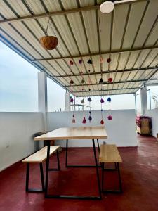 a table with benches and ornaments hanging from a ceiling at Galicia Lodgement in Lima