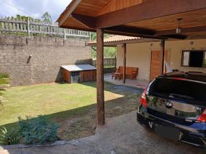 a car parked under a pavilion in a backyard at Chalé casa Visconde in Visconde De Maua +143 photos