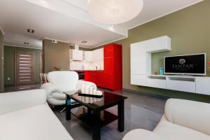 a living room with white furniture and red cabinets at Jantar Apartamenty Deluxe Sea View in Kołobrzeg