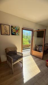 a living room with a chair and a sliding glass door at Gîte Le Verger in Traize