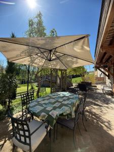 a table and chairs under an umbrella on a patio at Gîte Le Verger in Traize +67 photos