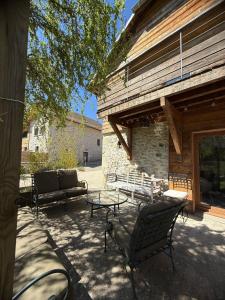a patio with chairs and a table and a building at Gîte Le Verger in Traize
