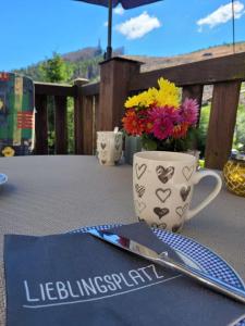 a table with a knife and a mug with flowers at Ferienwohnungen Dorfliebe Dörnberg WALDBLICK in Bestwig