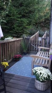 a wooden deck with a bench and some flowers at Ferienwohnungen Dorfliebe Dörnberg WALDBLICK in Bestwig