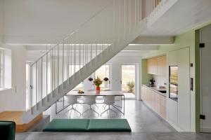 a kitchen with a dining table and a staircase at Ferring Neest in Midlum