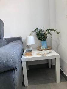 a white table with a lamp on it next to a couch at Alojamientos centro in Yecla +31 photos
