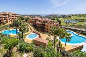 an aerial view of a resort with two pools and palm trees at Apartment with Private Terrace Calanova Golf by AORA STAY in Mijas Costa