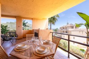 a wooden table on the balcony of a house at Apartment with Private Terrace Calanova Golf by AORA STAY in Mijas Costa
