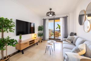 a living room with a couch and a flat screen tv at Apartment with Private Terrace Calanova Golf by AORA STAY in Mijas Costa
