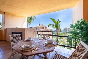 a wooden table on a balcony with a view at Apartment with Private Terrace Calanova Golf by AORA STAY in Mijas Costa