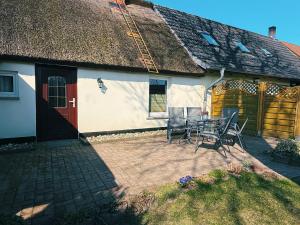 a house with a patio with a table and chairs at Ferienwohnung 2 Wald & See in Zirchow