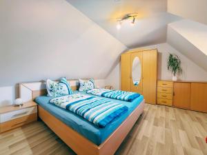 a bedroom with a bed with blue sheets and a dresser at Ferienwohnung 2 Wald & See in Zirchow