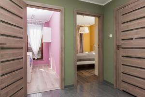 コウォブジェクにあるJantar Apartamenty Deluxe Sea Viewの緑とピンクの壁の客室とベッドルーム1室が備わります。
