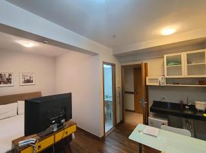 a living room with a large television and a kitchen at Suite Particular no Hotel S4 Águas Claras in Brasília +27 photos