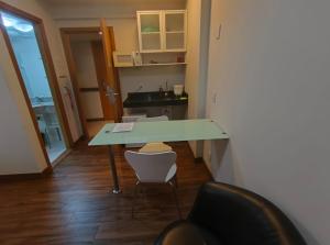 ein Tisch und Stühle in einem Raum mit Küche in der Unterkunft Suite Particular no Hotel S4 Águas Claras in Brasilia