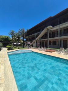a large swimming pool in front of a building at Pousada Margerie Ubatuba - Ítagua in Ubatuba