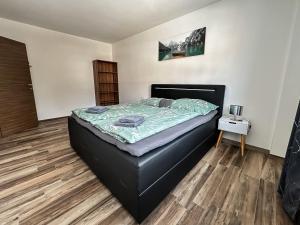 une chambre avec un lit avec un cadre de lit noir dans l'établissement Ours Living Tauernkogel - inkl Sauna, à Hollersbach im Pinzgau